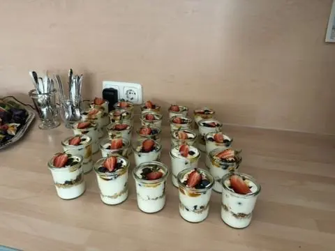 Viele Dessertgläser mit Früchten auf einer Arbeitsfläche