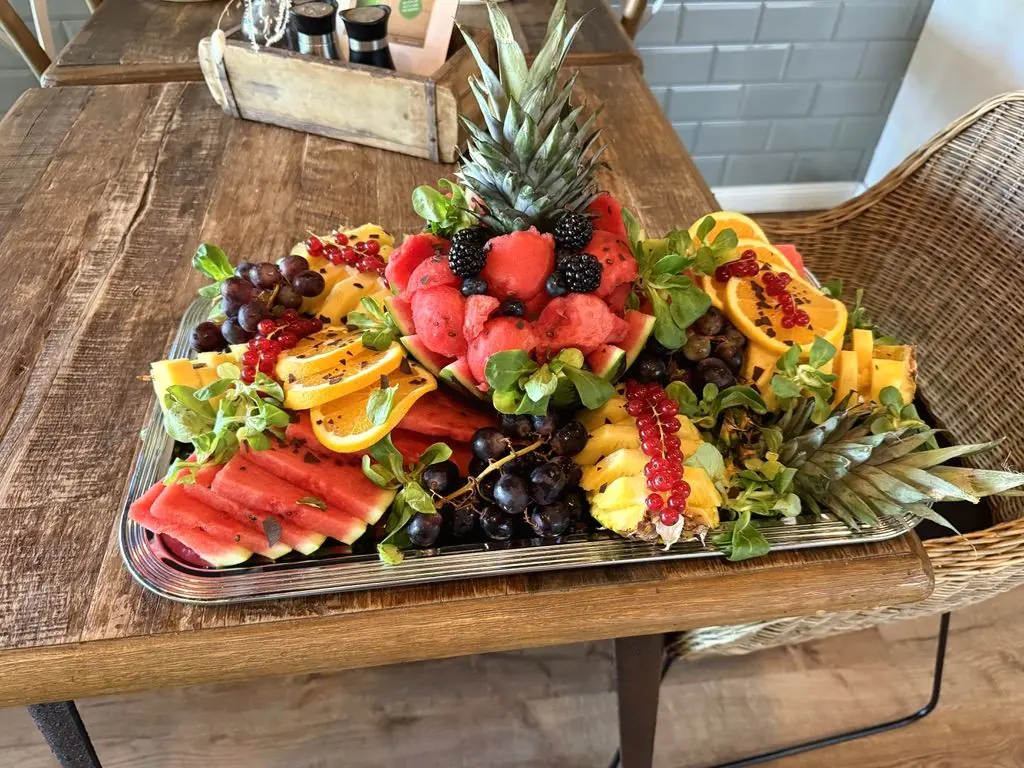 Große Obstplatte mit Ananas, Melone, Beeren und Trauben