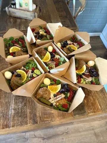 Mehrere offene Cateringboxen auf einem Holztisch